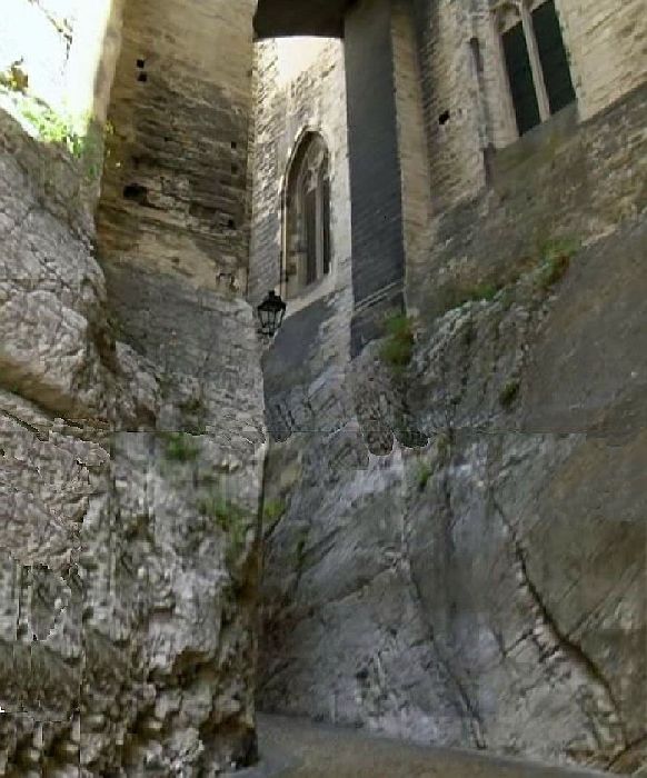 Ruelle pav&eacute;e le long du palais des Papes